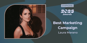 A woman in a black dress with the words "best marketing campaign" attends the Symphonic Awards.