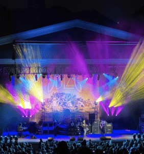 A concert with colorful lights on stage at night.