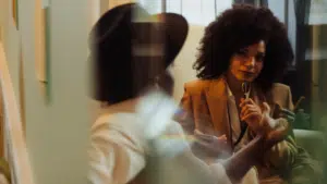 Two women engage in a meeting room conversation.