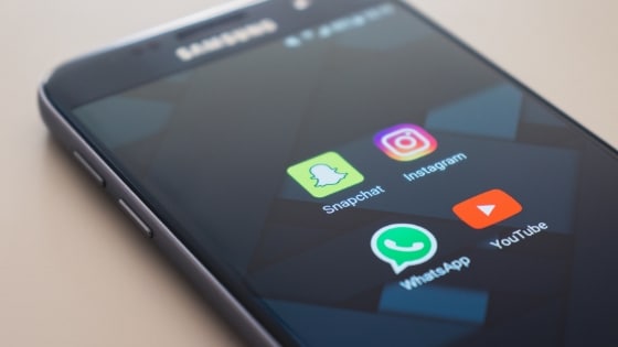 A samsung phone with instagram and whatsapp icons on it.