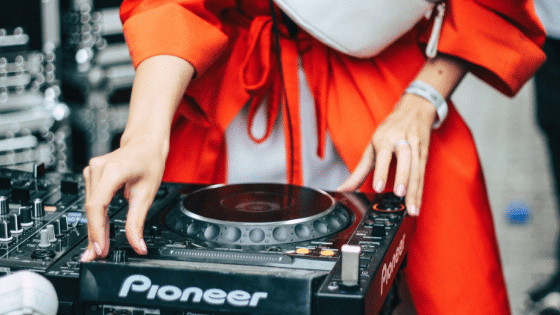 A woman in a red coat is holding a dj turntable.