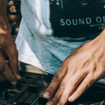 A dj's hands on a dj mixer.