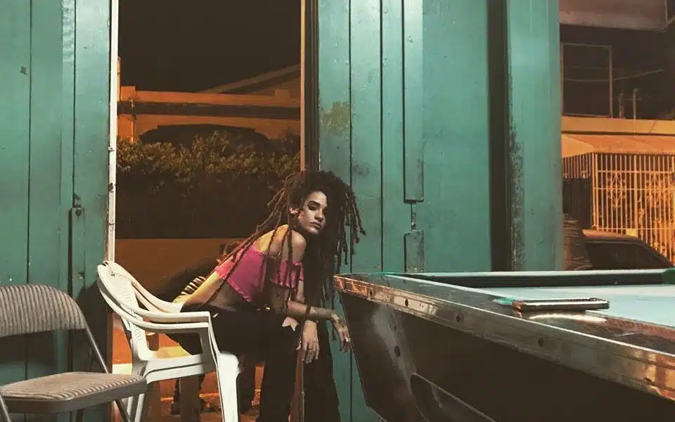 A woman standing next to a pool table.