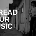 A black and white photo of a woman leaning against a wall with the words spread your music.