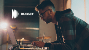 A man is working on a laptop in front of a dubset logo.