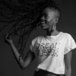 A black and white photo of a woman with dreadlocks.