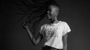 A black and white photo of a woman with dreadlocks.