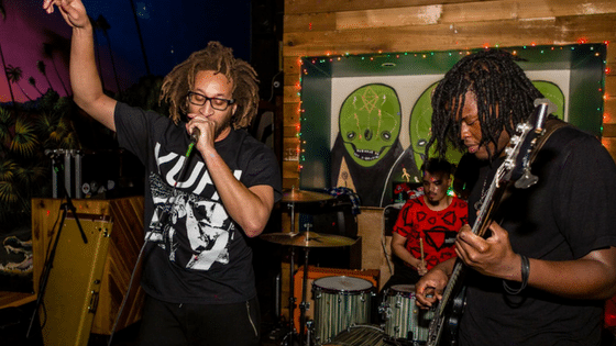 Two men with dreadlocks singing into a microphone.