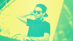 A dj wearing a hat and sunglasses in front of a green and yellow background.