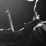 A black and white photo of a man playing a violin.