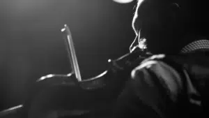 A black and white photo of a man playing a violin.