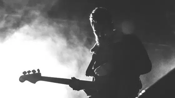 A black and white photo of a man playing a guitar.