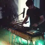 A man playing a keyboard in front of a microphone.