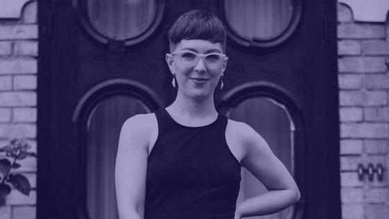 A woman in a black dress standing in front of a door.