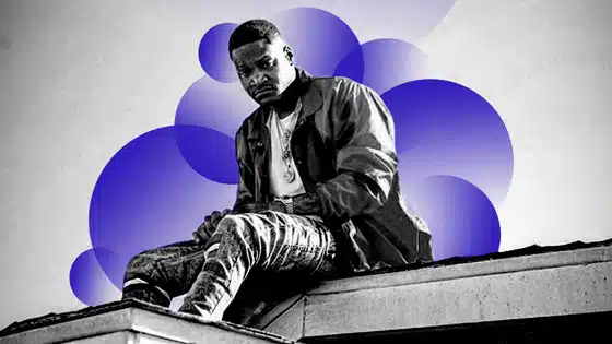 A man sitting on top of a building with a blue and purple background.