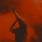 A silhouette of a man with his hands up in the air.