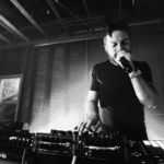 A black and white photo of a man in a dj booth.