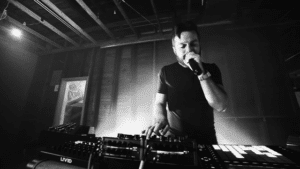 A black and white photo of a man in a dj booth.