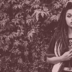 A black and white photo of a woman with dreadlocks.