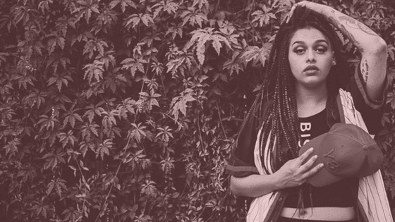 A black and white photo of a woman with dreadlocks.