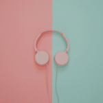 Pink headphones on a pink and turquoise wall.