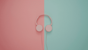 Pink headphones on a pink and turquoise wall.