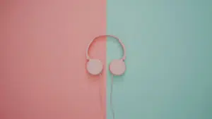 Pink headphones on a pink and turquoise wall.