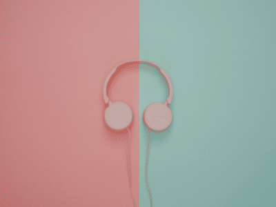 Pink headphones on a pink and turquoise wall.