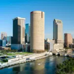 A city skyline with tall buildings and a river.