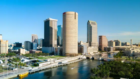 A city skyline with tall buildings and a river.