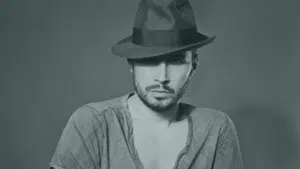 A black and white photo of a man in a hat.