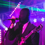 A man in a suit singing into a microphone.