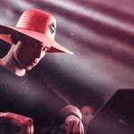 A dj wearing a hat at a concert.