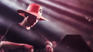 A dj wearing a hat at a concert.