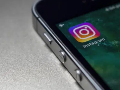 The instagram logo is displayed on an iphone.