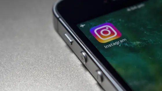 The instagram logo is displayed on an iphone.