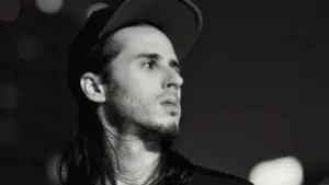 A black and white photo of a man with long hair.