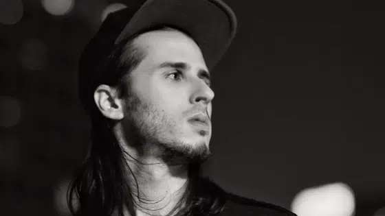 A black and white photo of a man with long hair.
