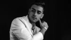 A black and white photo of a man in a white suit.