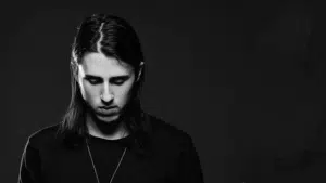 A black and white photo of a man with long hair.