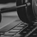 A black and white photo of headphones on a laptop keyboard.