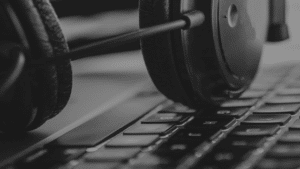 A black and white photo of headphones on a laptop keyboard.