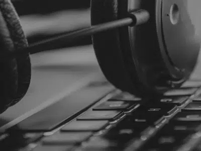 A black and white photo of headphones on a laptop keyboard.