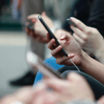 A group of people holding cell phones.