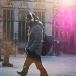 A man walking down a street with headphones on.