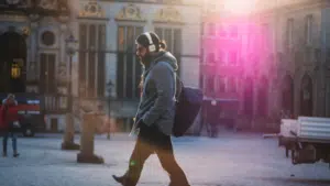 A man walking down a street with headphones on.