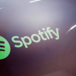 The spotify logo is shown on a pair of headphones.