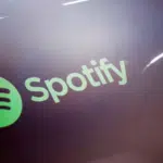 The spotify logo is shown on a pair of headphones.