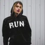 A woman wearing a black hoodie with the word run on it.