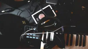 A black keyboard with headphones and a cell phone.